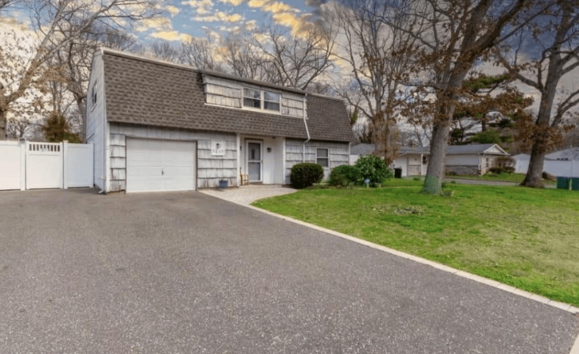 Front exterior of home before improvements in Holtsville, New York